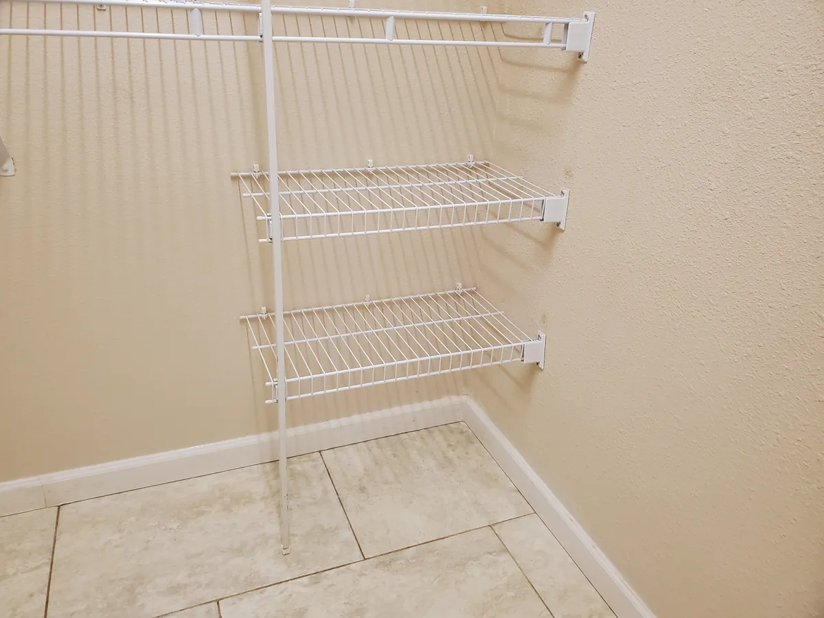 An empty closet after a move-out clean, with spotless tile and wire shelving