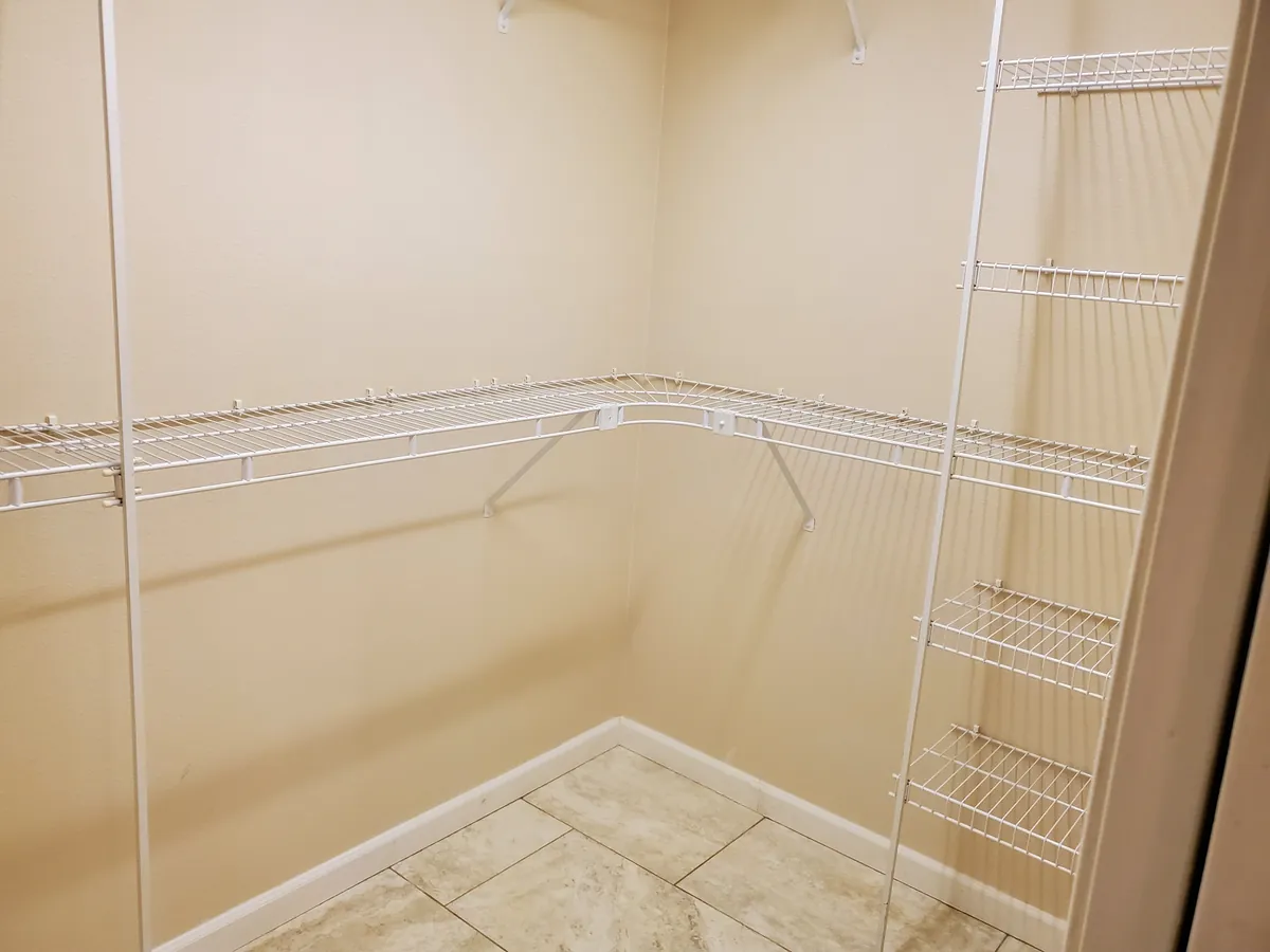 Empty closet after cleaning, with clean tile and wire shelving
