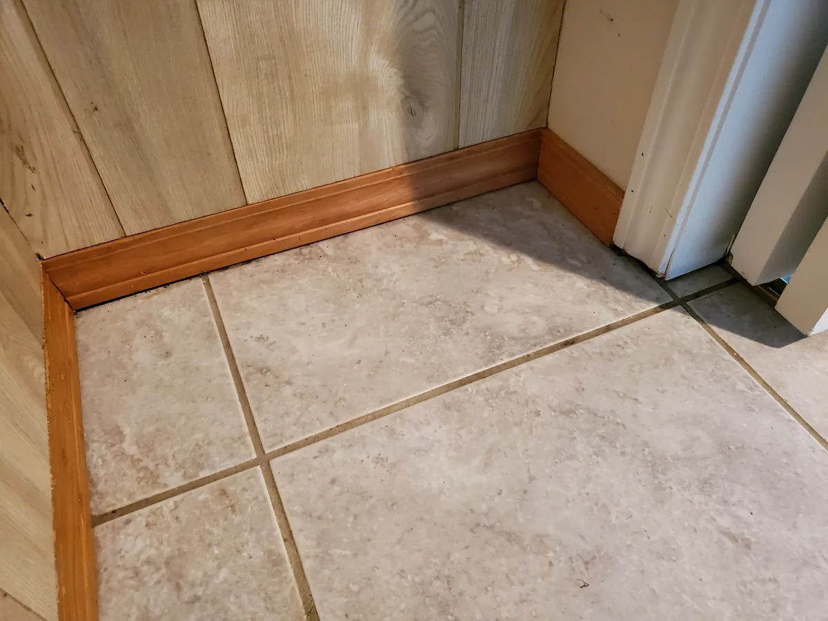 Closet corner after a clean, tile floor and baseboard clear