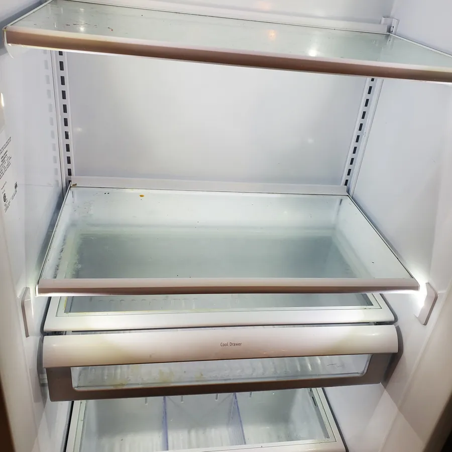 The same refrigerator before cleaning, with spills on the shelves
