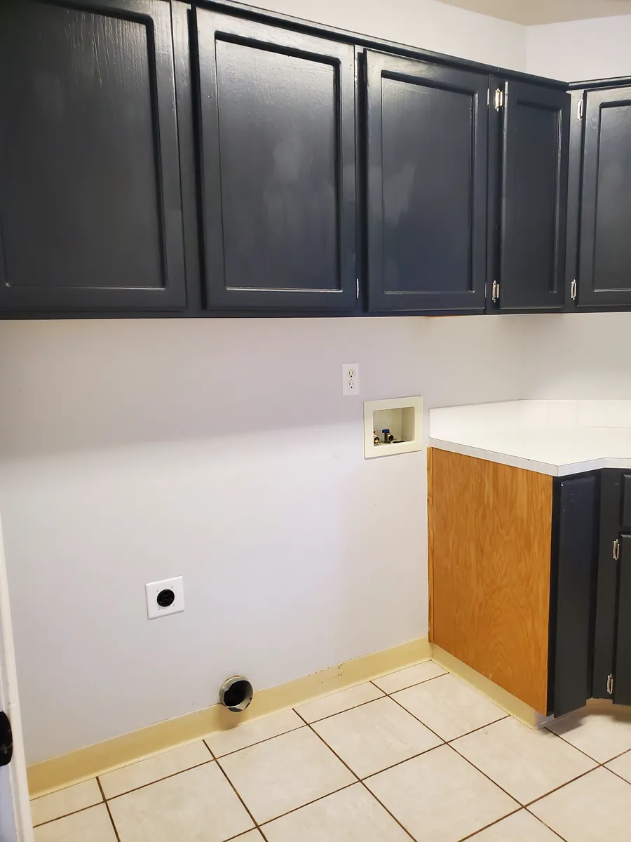 Laundry room with dark cabinets and a clean tile floor