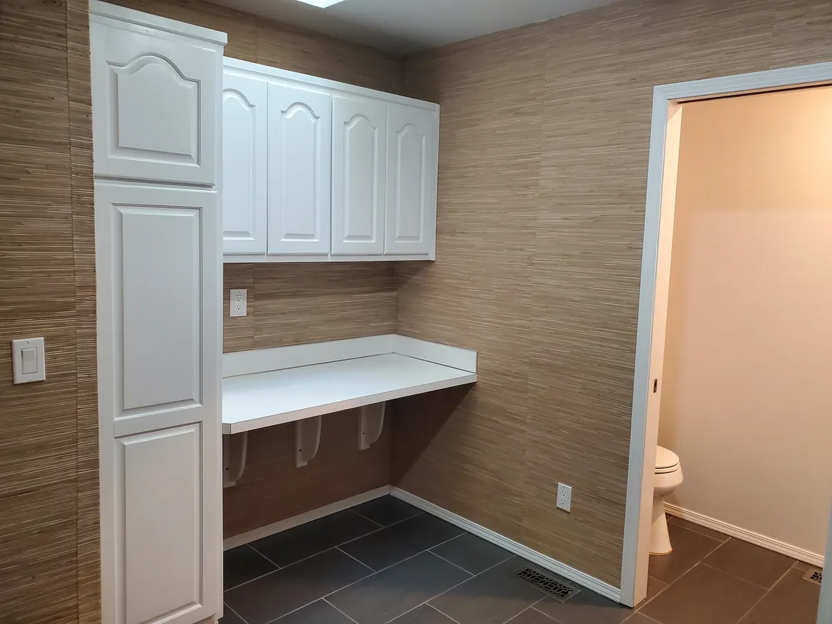 Laundry room with white cabinets and a folding counter