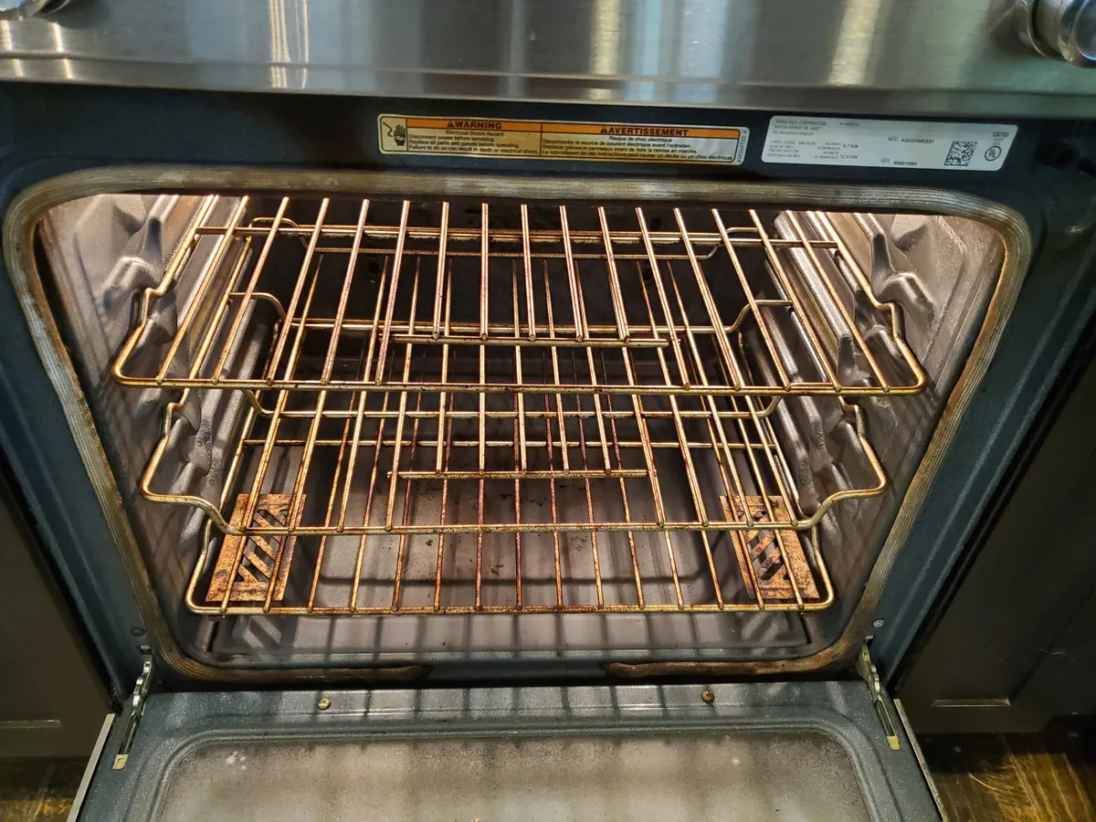 The same oven before cleaning, with rusted, grimy racks