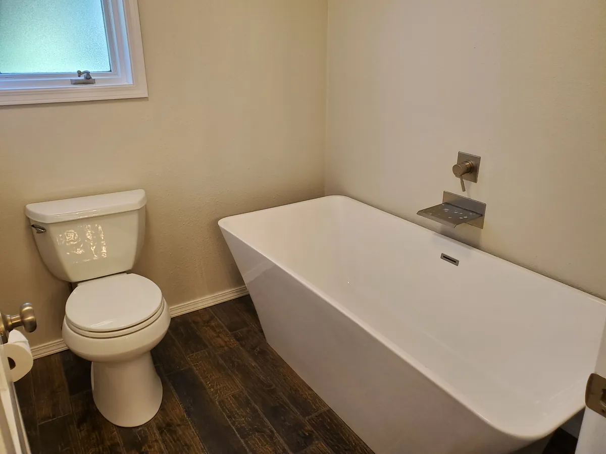 Bathroom after a clean, with a freestanding tub and toilet