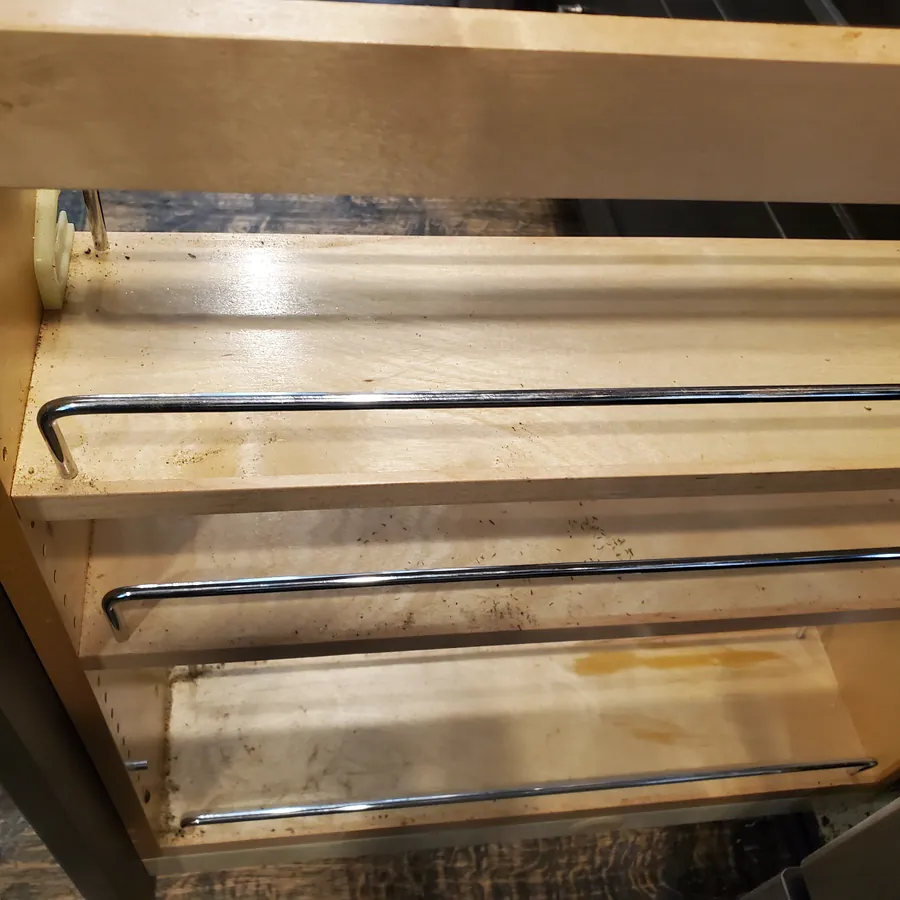The same pull-out spice cabinet before cleaning, with stains and debris
